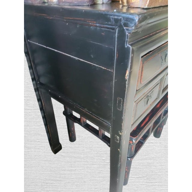 A black rustic 5 drawer ming leg console table. The table features a black rustic finish with 5 drawers and metal...