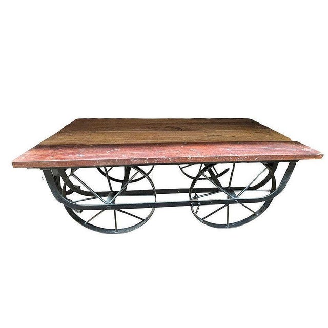 Iron and reclaimed wood coffee table fashioned after the railroad trolly carts of yesteryear showcases a captivating mix...
