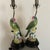 Gorgeous pair of lamps with green parrots seating on a tree branch. Head of parrots are accentuated with bright pink...