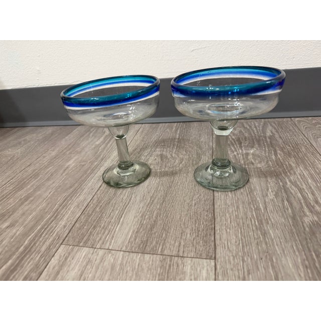 A bright and festive pair of blue‑rim margarita glasses, perfect for summer entertaining, bar carts, or coastal‑inspired...