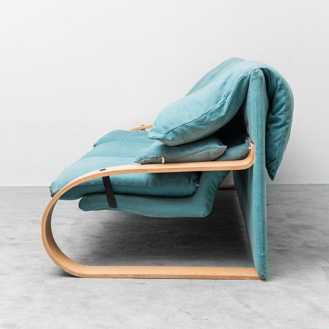 Alvar Aalto-style 3-seater sofa. Light blue fabric upholstery. Curved wood armrests. Excellent condition. Signs of wear as...