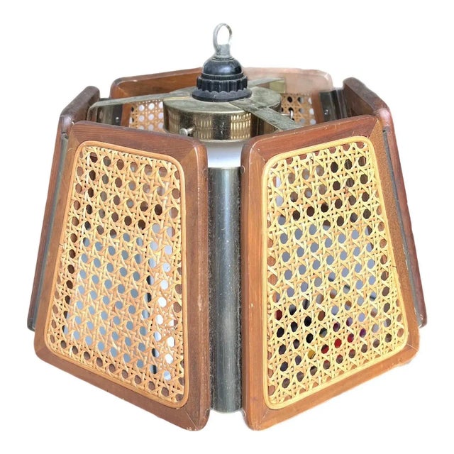 This late mid-20th century chandelier/pendant light has six cane panels with a wood frame and brass accents. It is the...