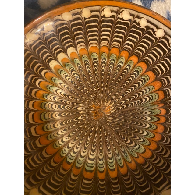 Vintage earthenware slip glazed decorative plate made in Horeza, Romania in the iconic peacock pattern. This piece is...