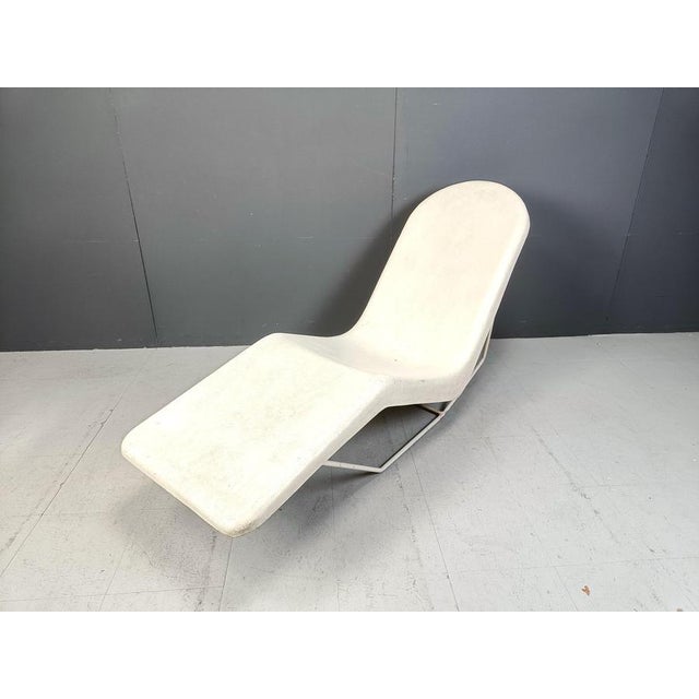 Mid century chaise longue made from a fiberglass shell mounted on a white metal frame. Beautifully weathered chair which...
