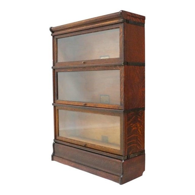 An antique Globe-Wernicke sectional barrister bookcase, crafted from quartered oak in the distinguished Arts & Crafts...