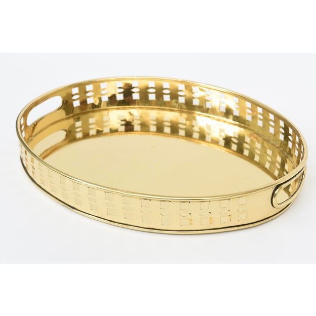 This wonderful vintage oval brass tray has square cutouts with handles. From the 80's. Great barware and for entertaining.