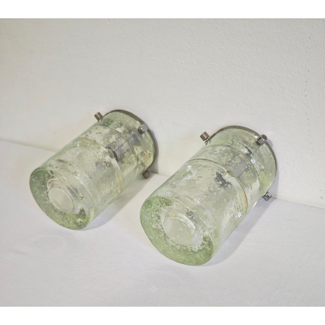 Albano poli production by poliarte, 1960/70. Two table or wall lamps with a colorless murano glass diffuser. This pair of...