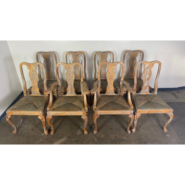 This is a charming set of eight carved wood dining chairs, including six side chairs and two armchairs, all in a classic...