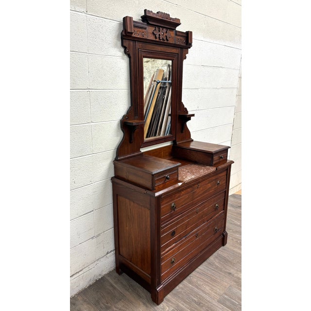 This is an exceptional antique Victorian Eastlake walnut dresser with towering architectural mirror, dating to...
