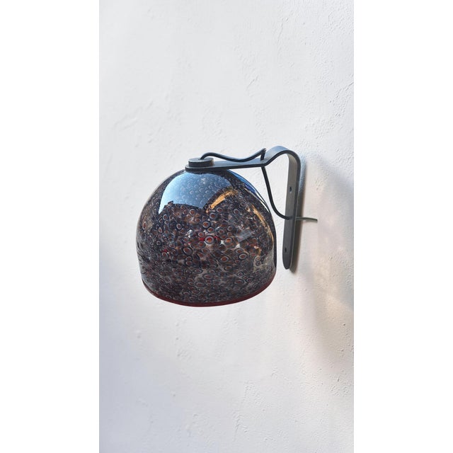 Murano glass wall lamp with Murrine, Neverrino model, by Gae Aulenti for the Vistosi glassworks. Made in the 1970s, it...