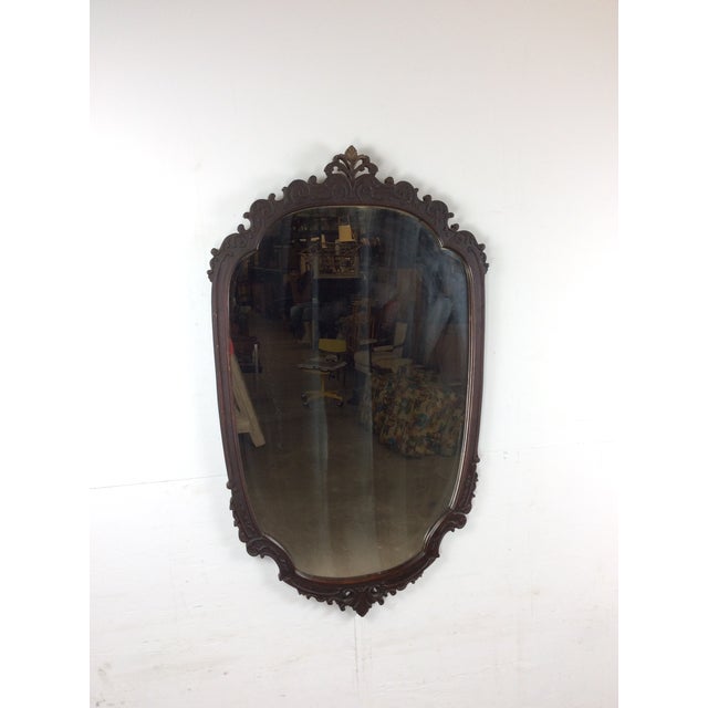 This antique wall mirror features hardwood frame, original dark finish, carved wood detailing throughout, and original...