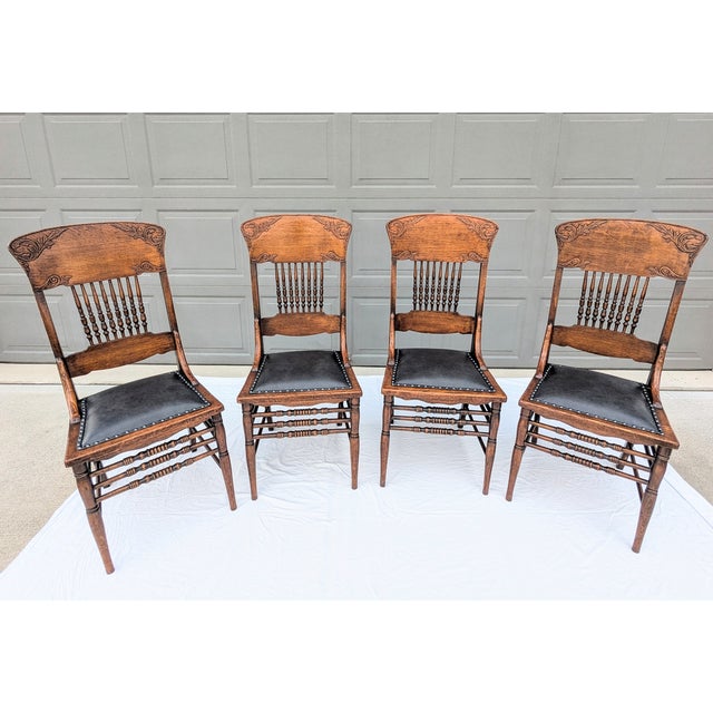 These are four antique pressed back spindle dining chairs, made of oak, are estimated to be from the late 1800s. The top...