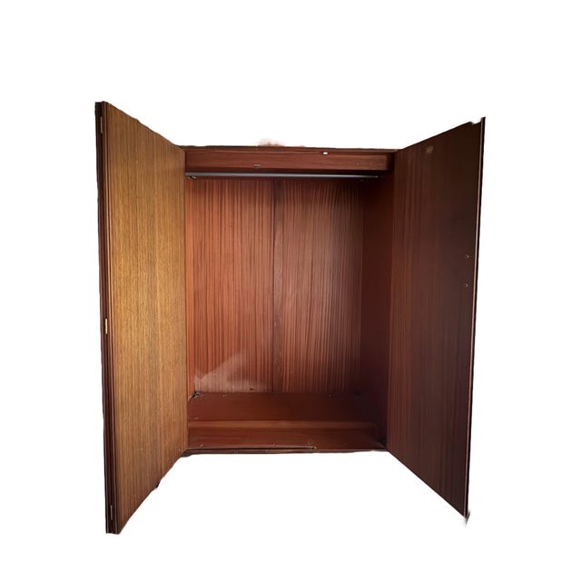 G Plan large wardrobe with bifold doors and one swinging door. Single 46.5” hanging rod inside. Teak with brass handles....