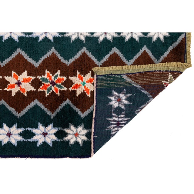Handwoven in Turkey, this vintage runner features striking geometric motifs and a rich, earthy palette inspired by...