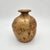 Hand-thrown stoneware bud vase with warm amber speckled glaze, flared lip, bulbous body, and signed base