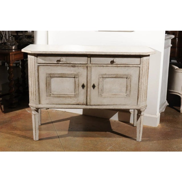 A Swedish painted wood sideboard from the late 19th century, with two drawers, two doors, canted side posts and tapered...