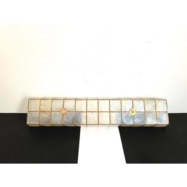 Large mid century Capiz shell wall light from the Philippines in a flared rectangular shape with gold frame and two light...