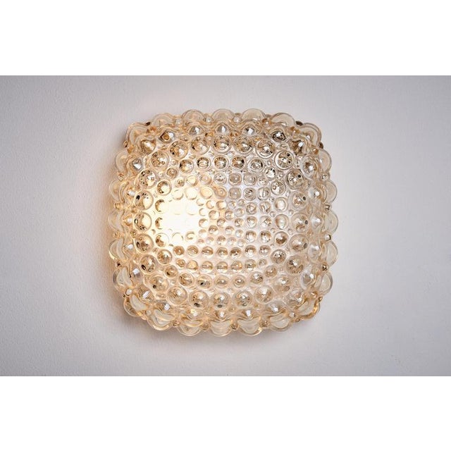 Wall or ceiling lamp featuring a pressed light-amber glass hood with a square, bubble-textured diffuser, mounted on a...