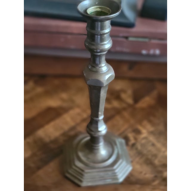 Vintage, octagonal-base brass candlestick, which shares stylistic characteristics with Georgian or Louis XIV period...