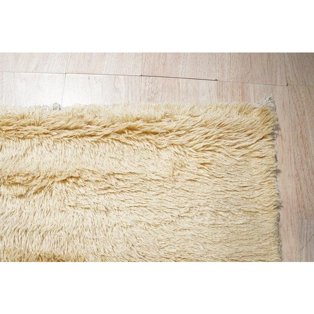 This hand knotted pile rug features a vibrant color palette dominated by yellow, gold, and orange hues. Made from wool,...