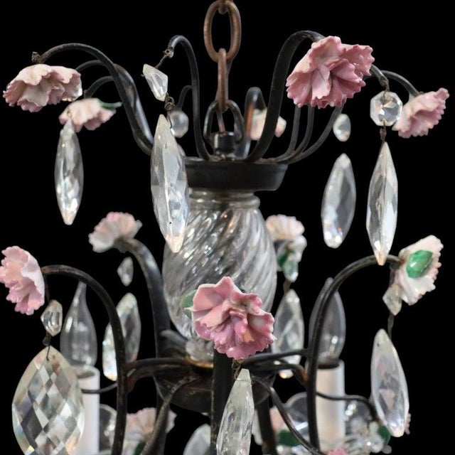 This vintage five-light chandelier, dating to approximately 1940, features an ebonized iron frame adorned with delicate...