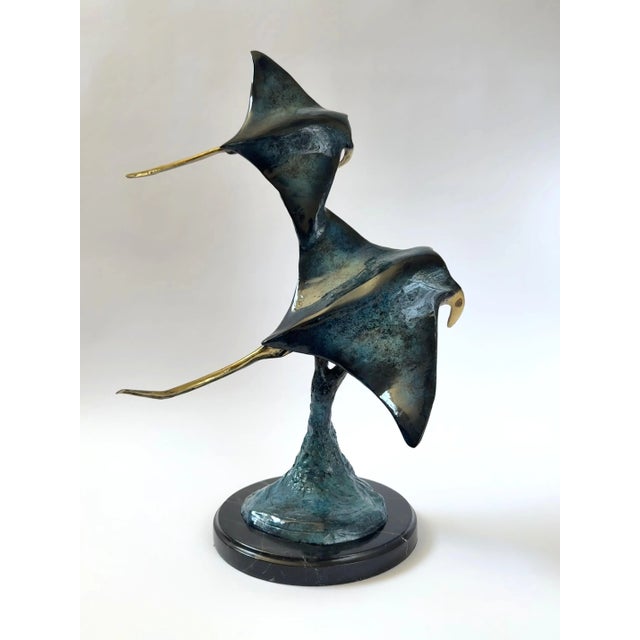 This bronze sculpture captures the grace of two manta rays gliding through the ocean currents. Beautifully crafted with...