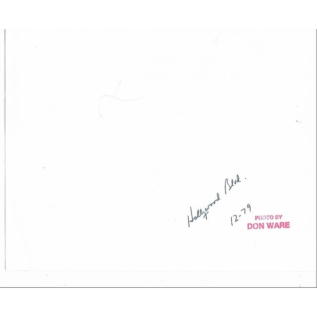 1979 black and white photograph by Los Angeles photographer Don Ware of riders at a bus stop on Hollywood Blvd outside a...