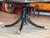 A large round ebonized dining table with a bold gilt Greek key border running the full circumference of the top and a fine...
