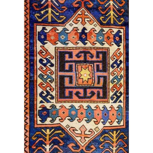 A wonderfully "tribal" 19th century Kazak rug with boldly woven floral, vegetable and animal motifs woven in crimson,...