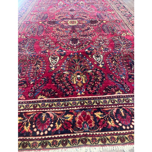 This elegant antique Persian Sarouk rug, woven around 1920, is a beautiful example of the classic Sarouk tradition,...
