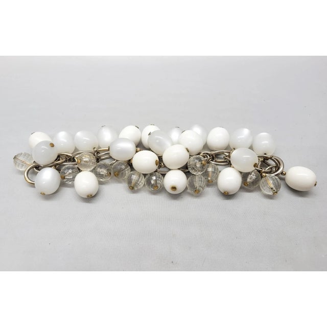 This is part of Chairish’s Costume Jewelry assortment. 1950s goldtone ovoid white resin and white "moonglow" faux-...