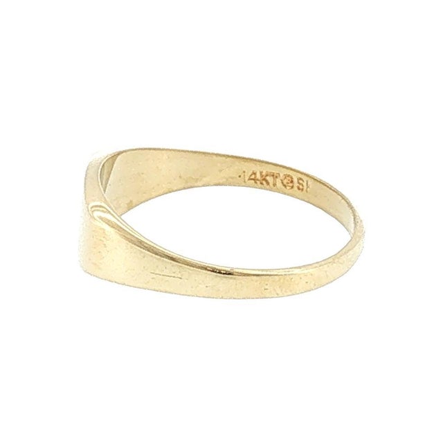 A simple late 20th-century vintage 14k gold horizontal signet ring. The ring features a smooth, rectangular face with a...