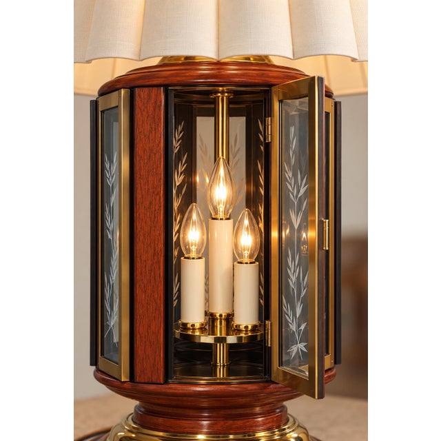 A striking matched pair of oversized lantern-form table lamps, combining warm reddish-brown wood, bright brass detailing,...