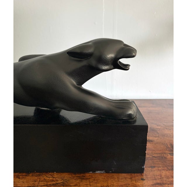 Vintage Art Deco revival black panther sculpture crafted in a dramatic elongated feline form and mounted upon a...