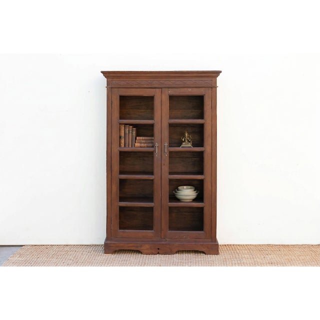 This Antique piece, is a commanding 70-inch bookcase that exemplifies the architectural elegance of the Colonial era....