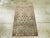 An antique Indian Lahore throw rug. The design looks like a part of a larger, repeating composition. An open lozenge...