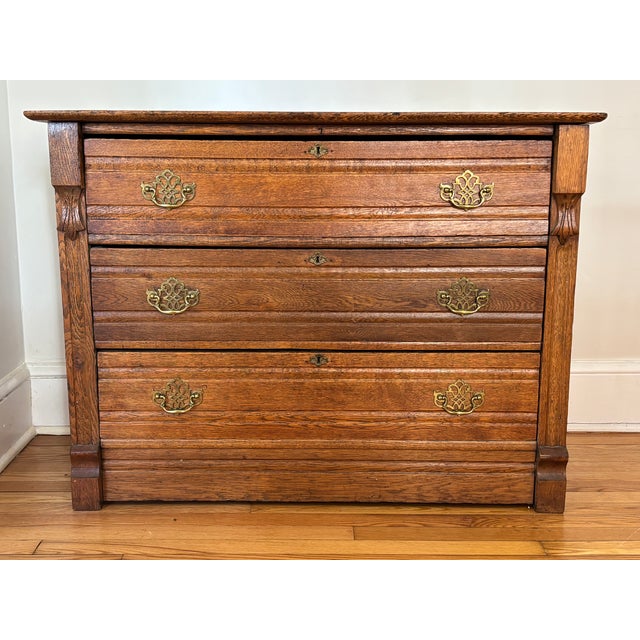 Beautiful 19th century Victorian Eastlake chest of drawers, made of oak. Features three wide dovetailed drawers, as well...