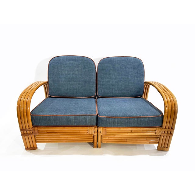Two-seater modular rattan sofa with blue fabric cushions and seat base coverings. The four loose cushions are 4 3/8"...
