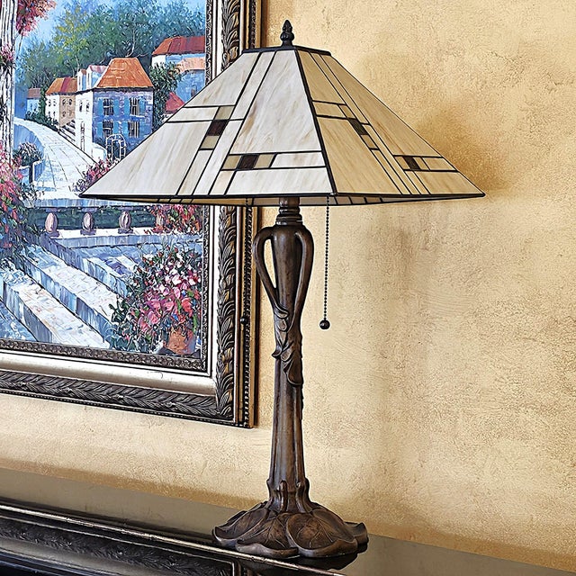 Handsome KL Tiffany-style Mission table lamp, featuring a sculptural bronze-tone metal base with flowing botanical and...