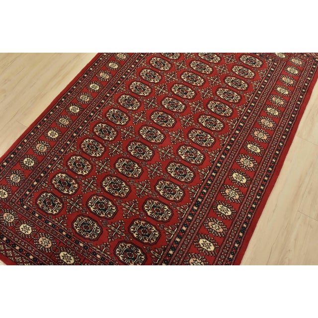A tribal Bokhara rug hand-knotted with fine wool on a cotton foundation. This rug features rows of repeating medallions...