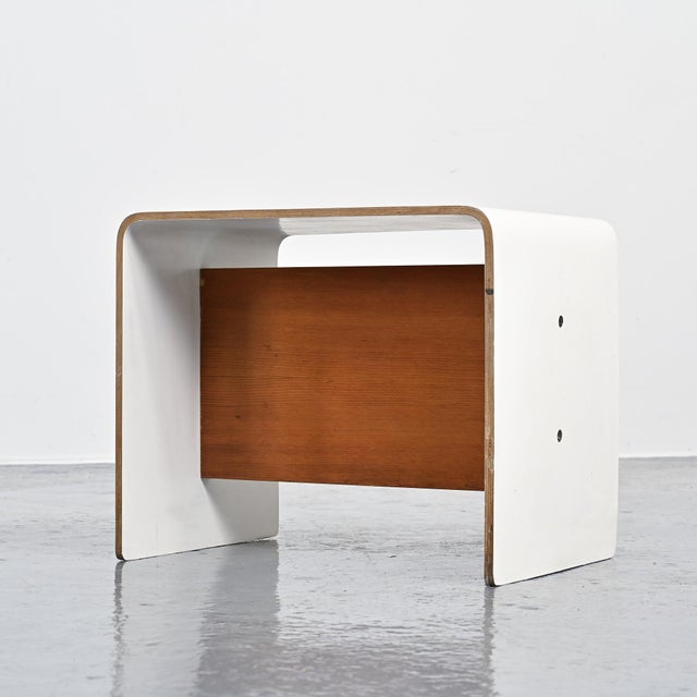 Bedside table designed by Pierre Guariche for apartments in La Plagne and Bandol. Made of U-shaped bent plywood, covered...