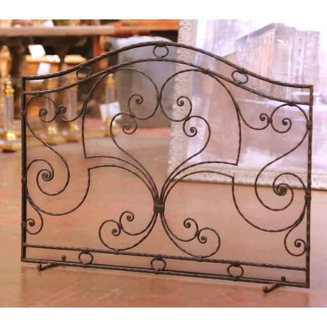 Decorate a hearth with this elegant antique wrought iron fire screen from France, crafted circa 1960. The tall single-...