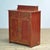 This pine cabinet from circa 1920 combines a timeless look with practical storage space. The piece features two small top...