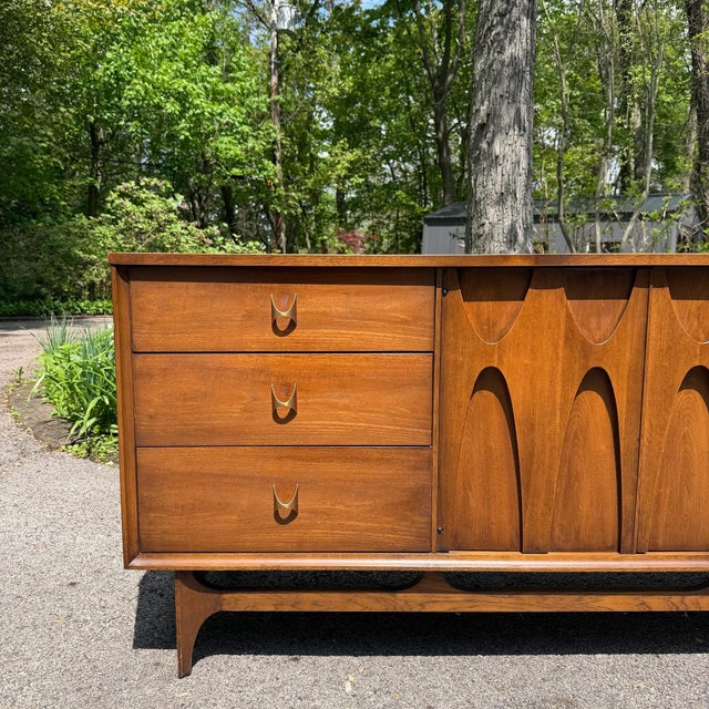 Mid Century Modern lowboy dresser from the Broyhill Brasilia series. This dresser features sculptural walnut arches...