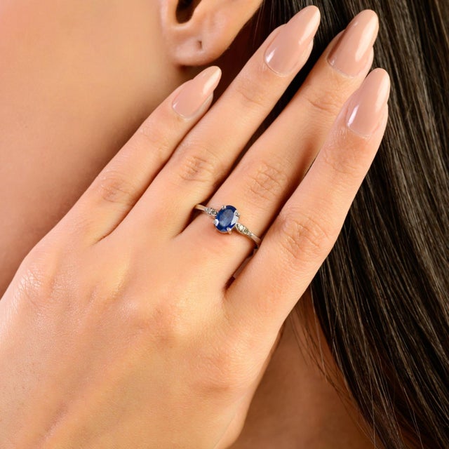 This 925 Sterling Silver minimalist ring features an elegant oval blue sapphire in a classic prong setting, measuring 7×5...