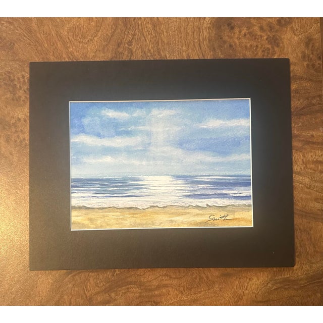 Soft morning light dances across the water in this peaceful original watercolor seascape. Gentle waves meet a sandy...