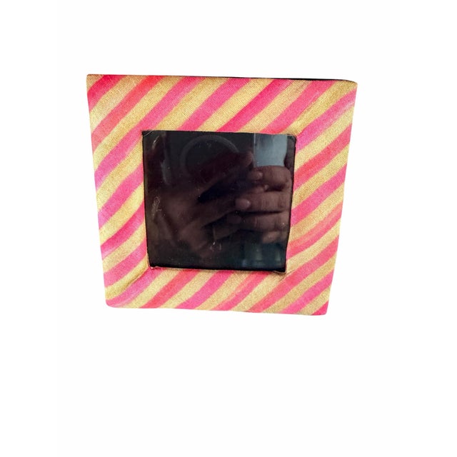 Charming MacKenzie-Childs 4” x 4” picture frame featuring bold diagonal stripes in vibrant pink and warm gold tones. The...