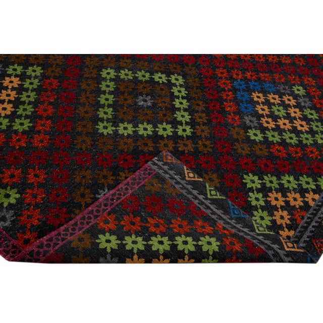 Beautiful modern Soumak hand-knotted wool rug with a dark gray field. This piece has multicolor accents in a gorgeous all-...