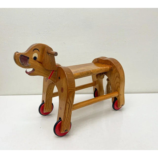 A cute vintage dog on wheels from the 1950s-1960s. This toy dog has a seat for a child and can be used as a toy car. The...