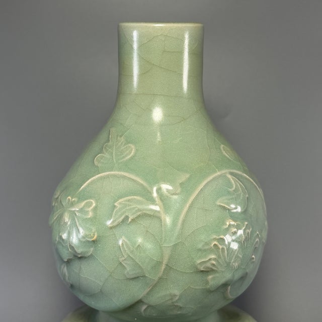 Fine antique Chinese celadon double‑gourd vase. Classic double gourd silhouette adorned with raised floral relief carving,...